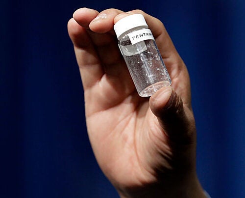 A reporter displays the volumetric equivalent of a fatal dose of fentanyl, a potent synthetic opioid that is being cut with heroin and posing greater risk to users and even first responders.