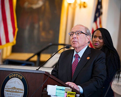 To honor its 150th anniversary, the Boston City Council recognizes Harvard School of Dental Medicine at Faneuil Hall. Dean R. Bruce Donoff (standing) addresses the council, while Councilor Ayanna Pressley looks on. The School is hosting an open house today.