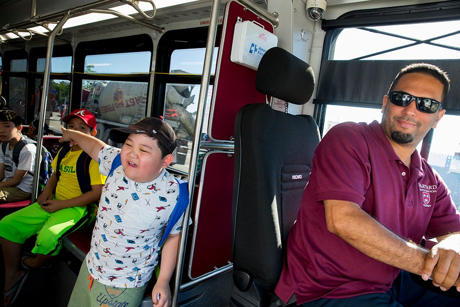 Kevin Nguyen, 9, says goodbye to his mother after boarding the Harvard shuttle. Dennis Pena is at the wheel.