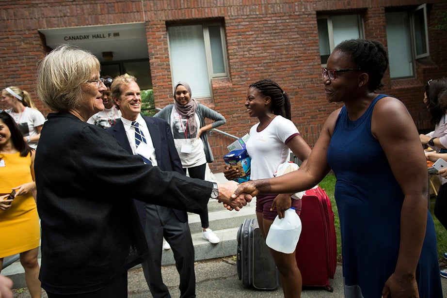 President Faust (from left) and Dean of Freshmen Tom Dingman meet with students and families, including Ruva Chigwedere ’21 and her mother Lorine, from Florham Park, N.J., in front of Canaday Hall. Stephanie Mitchell/Harvard Staff Photographer