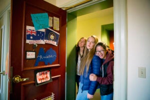 Roommates Kristie Colton (from left), Georgia Seidel, and Rebecca Chen peak inside their room in Thayer Hall.