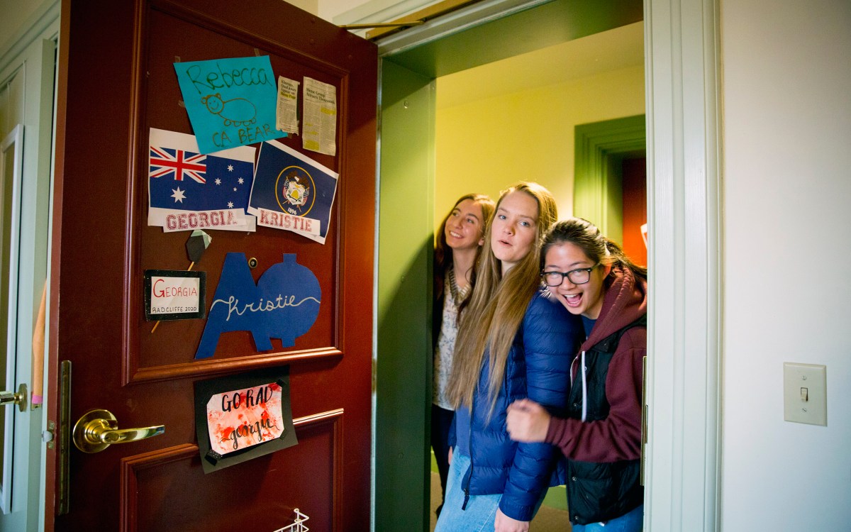 Roommates Kristie Colton (from left), Georgia Seidel, and Rebecca Chen peak inside their room in Thayer Hall.