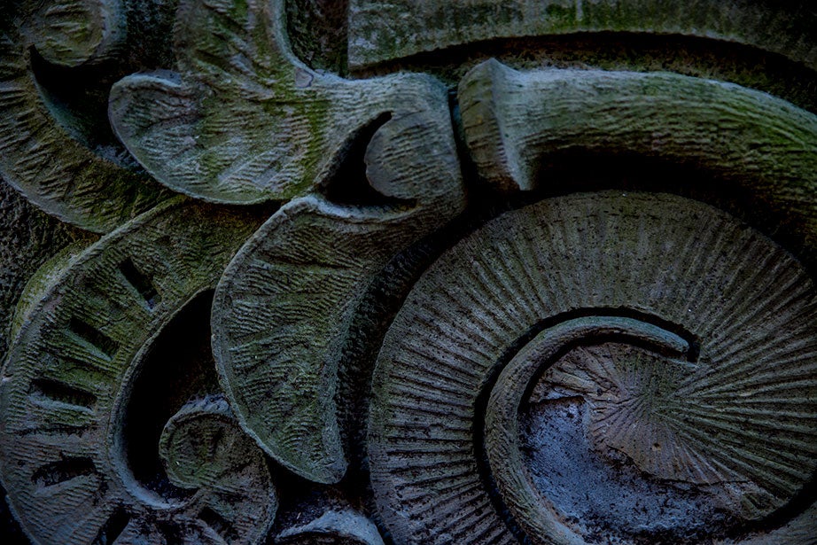 Intricate stone carvings loop on a block in a hidden corner.