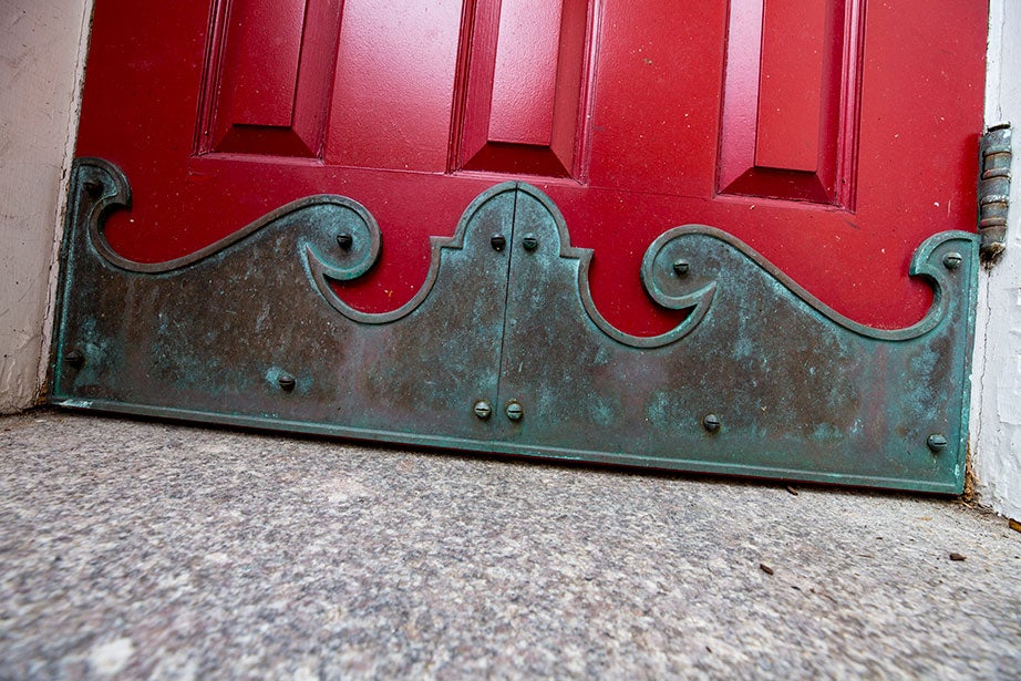 Detail of a brass wave on the bottom of a door in the courtyard.