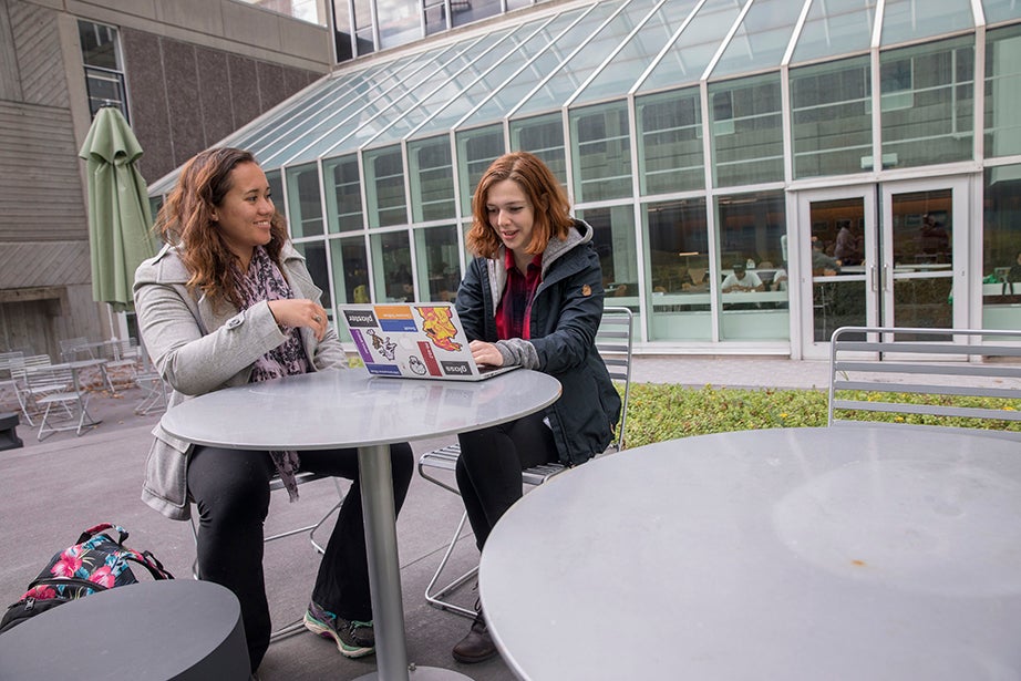 Leilani Doctor HLS '19 (left) and Eleanor Lieberman '19 opt for a table outside on a warm day. Kris Snibbe/Harvard Staff Photographer