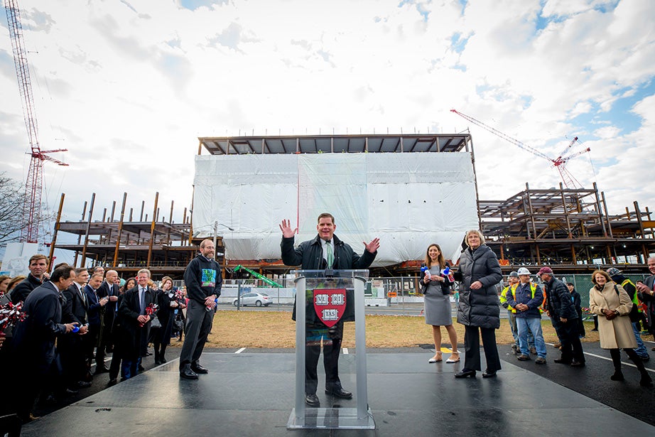 Harvard Provost Alan Garber, Mayor Martin J. Walsh, and President Drew Faust prepare to give the signal to raise the final beam of the Science and Engineering Complex in Allston.