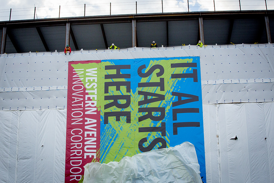 Members of the construction crew reveal a banner facing Western Avenue.