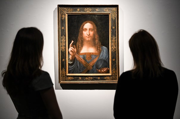 Gallery workers view Leonardo da Vinci's 'Salvator Mundi' painting at Christie's Auction House.