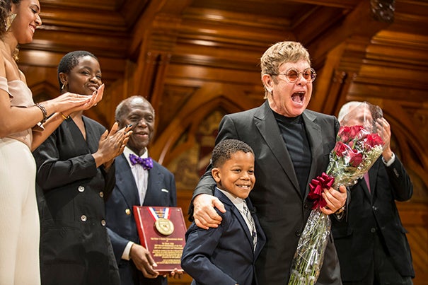 Chase Sullivan, 8, presents Sir Elton John with flowers at Monday's ceremony held at Sanders Theatre.