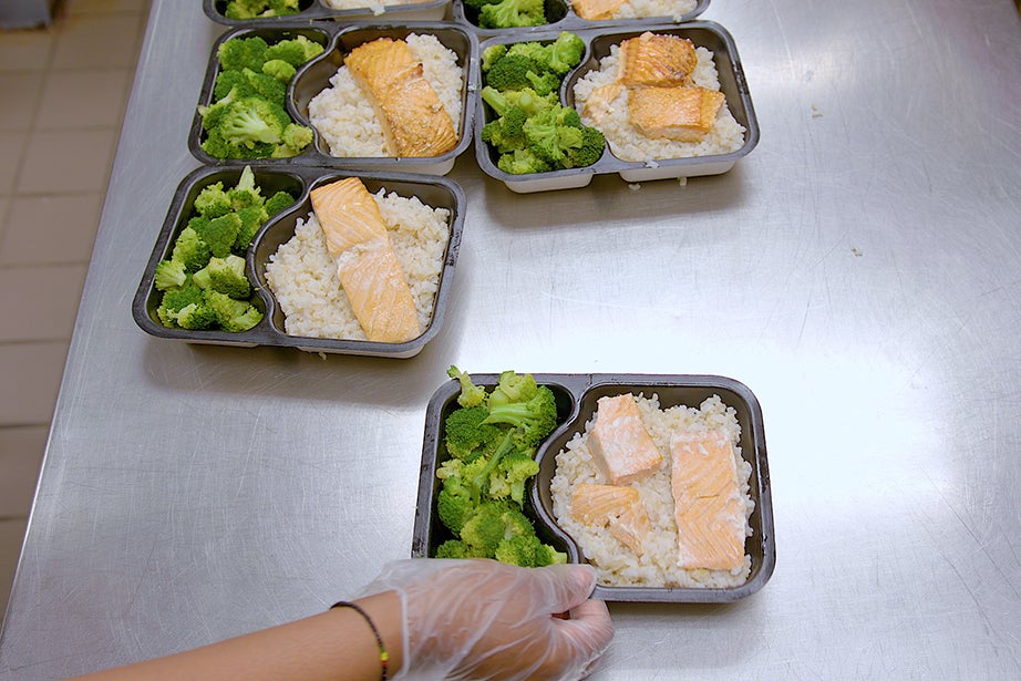 Individual meals of salmon, rice, and broccoli.