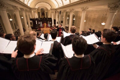 Choirmaster conducts Harvard choir during Christmas service in Memorial Church.