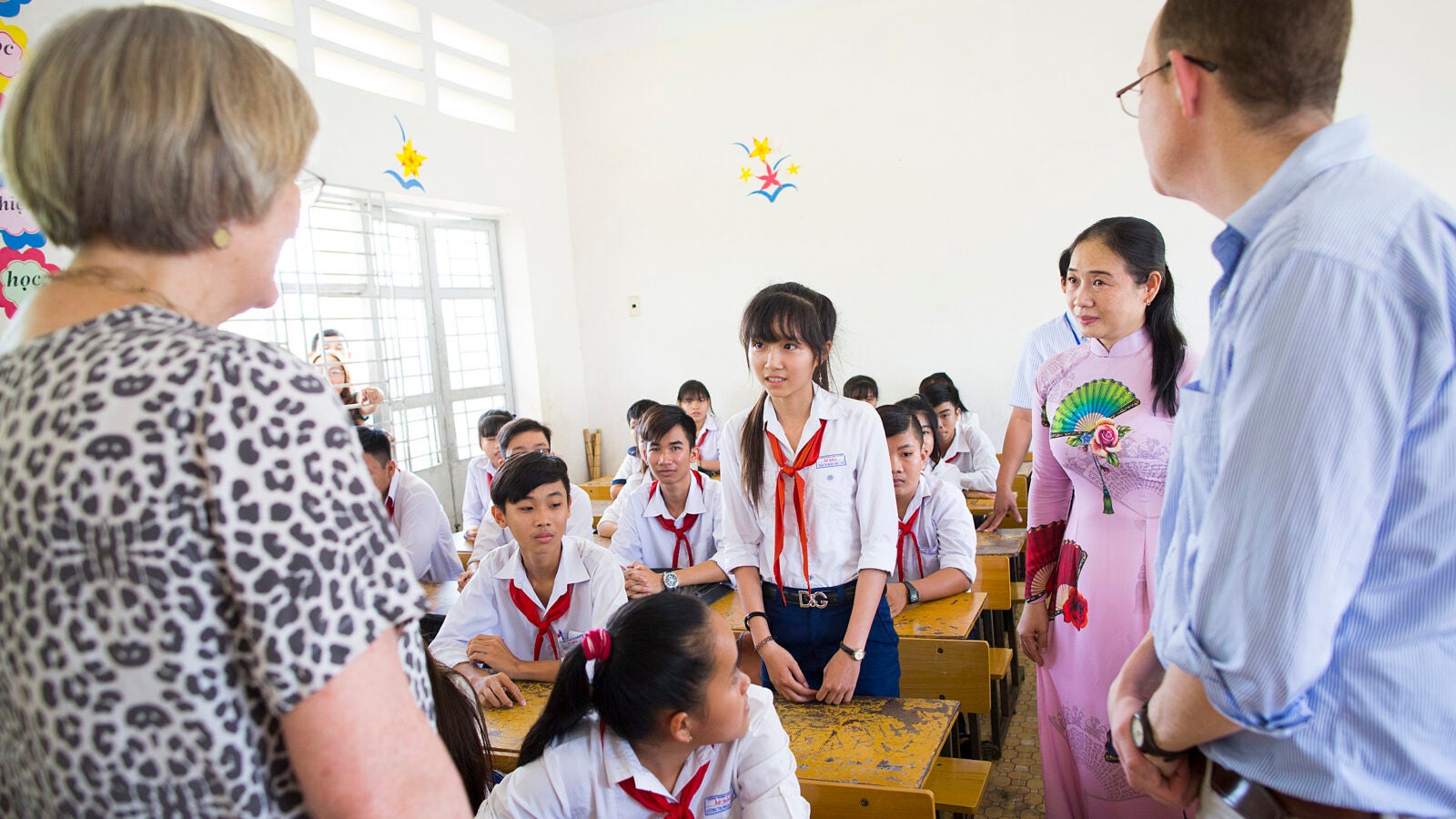 Children in a Vietnamese classroom talk with Harvard President Drew.