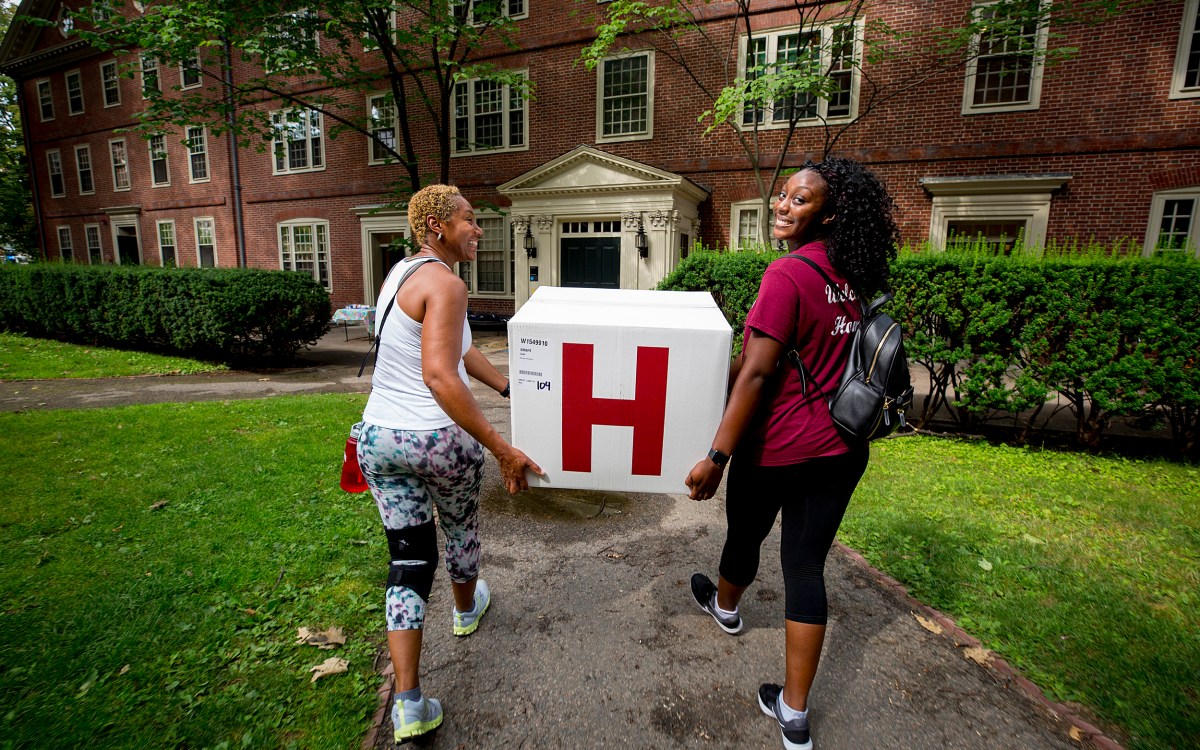 Freshman Leah Smart and her mother, Dee, carry box into Harvard dorm.