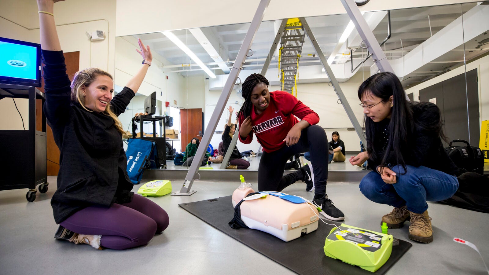 Fitness instructor Christina Hoff (from left), Sope Adeleye ’20, and visiting scholar Qingqing He ’18 participate in American Heart Association Heart Saver CPR and AED (automated external defibrillator) training for adults, children, and infants. Rose Lincoln/Harvard Staff Photographer