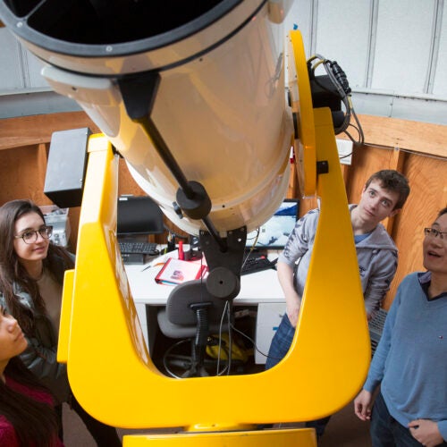 CRLS students Sophia Sonnert (from left), Tatiana Athanasopoulos, and Jonas Hansen meet with Harvard postdoc George Zhou at the Clay Telescope at the Science Center. Zhou is a mentor in the Science Research Mentoring Program at the CfA.