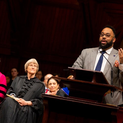 Neil Shubin, Ph.D. ’87, (from left) and Harvard President Drew Faust listen to poet Kevin Young '92 recite poetry from his latest book during Phi Beta Kappa Literary Exercises for the Class of 2018.
