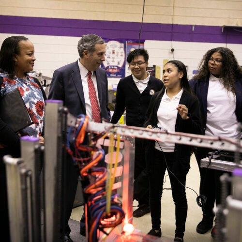 Harvard President Larry Bacow visits the International Technology Academy in Pontiac, Mich. Harvard Graduate School of Education Dean Bridget Terry Long (from left) and Bacow speak with students Haitau Yang, Darcy Mendoza, and Rebecca Murray in the robotics lab of the school. 