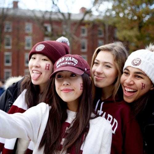 Harvard students Lucy Lu (from left), Elyse Pham, Isabel Isselbacher, and Alexandra Diggs pose for a selfie at a tailgate party in Science Center Plaza before they headed to the Harvard-Yale game at Fenway Park. Photo by Olivia Falcigno