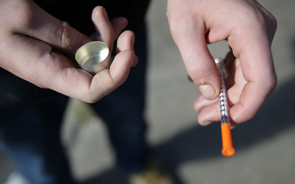 A fentanyl user holds a needle.