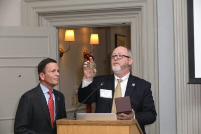 dgar Grossman’s son Steven looks on as Dean Hunt Lambert present him with a medal honoring his father’s contributions to Harvard Extension School (photo Alex Gagne)