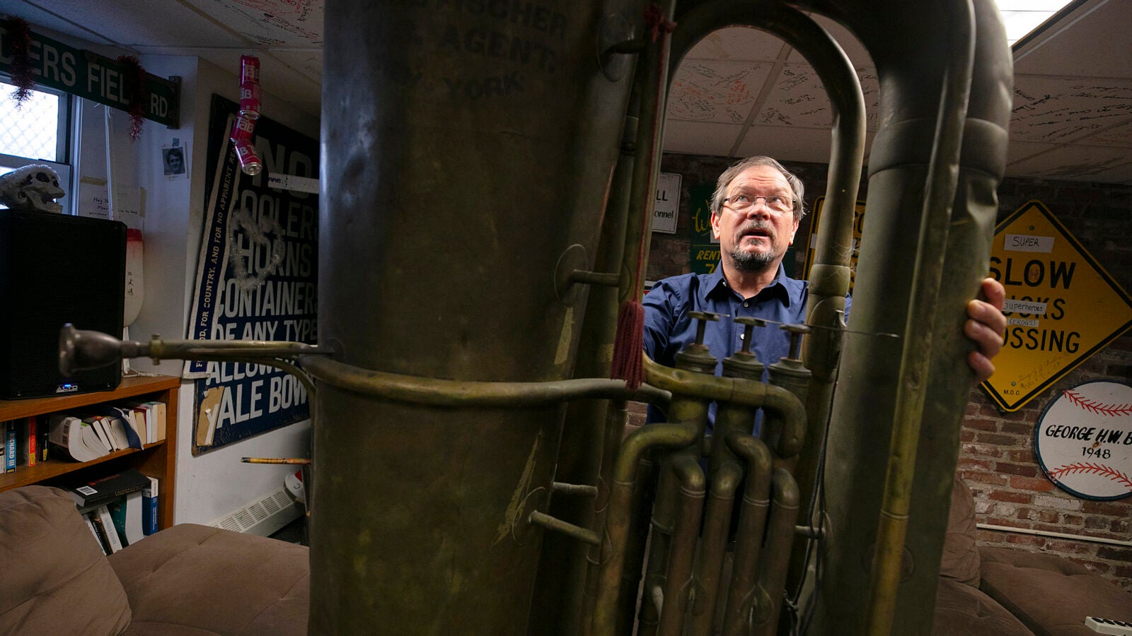 A man standing behind a giant tuba