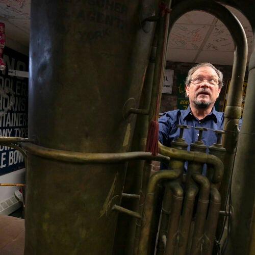 A man standing behind a giant tuba
