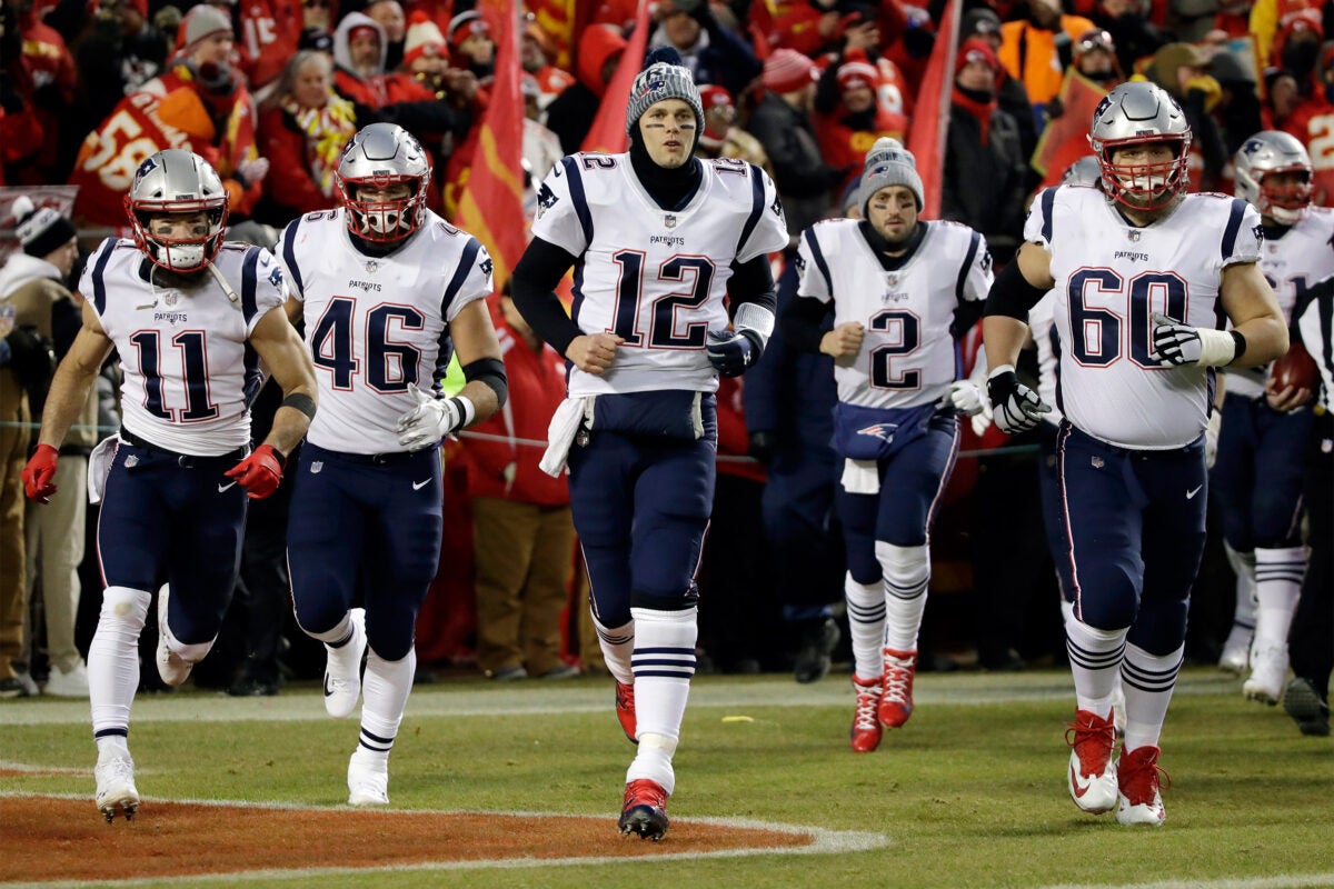 Tom Brady leads the Patriots onto the field.