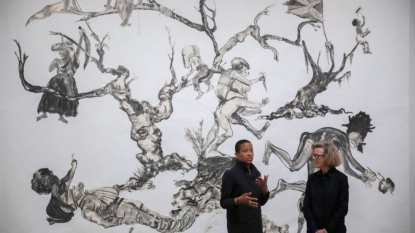 Chassidy Winestock and Mary Schneider Enriquez with Kara Walker's art U.S.A Idioms..