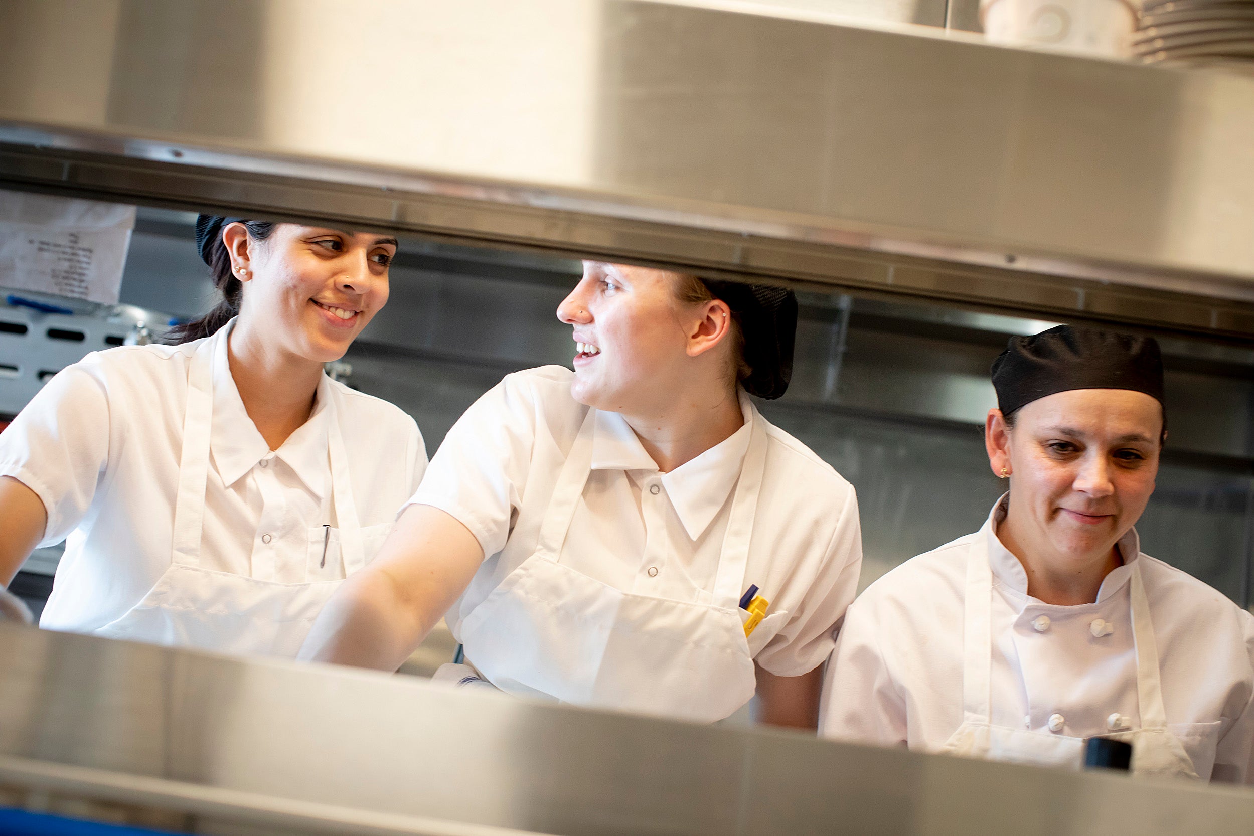 Chefs, Vanessa Portiza Acosta, from left, Corrine Gaucherin and Luz Restrepo Rincon work on the line in the kitchen at The Heights