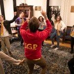 Students in a circle strike poses to practice their improv techniques.