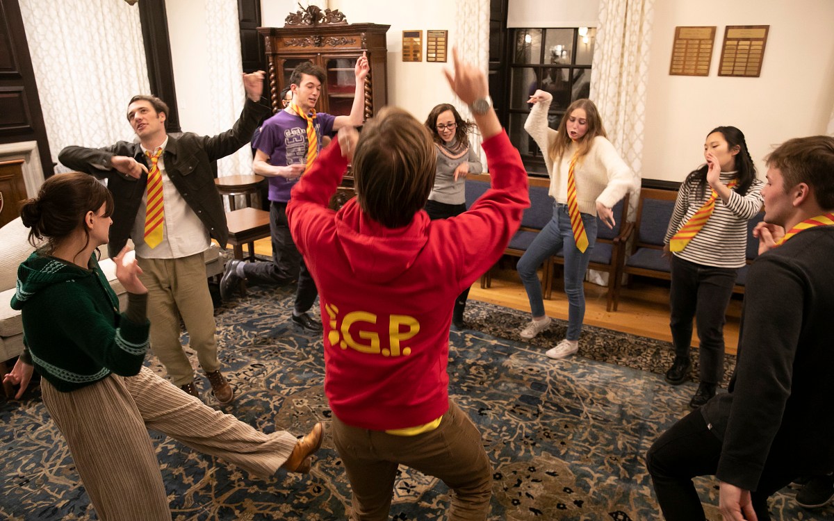 Students in a circle strike poses to practice their improv techniques.