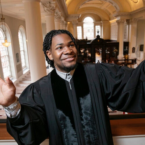 Aric Flemming in a priest's gown standing in church