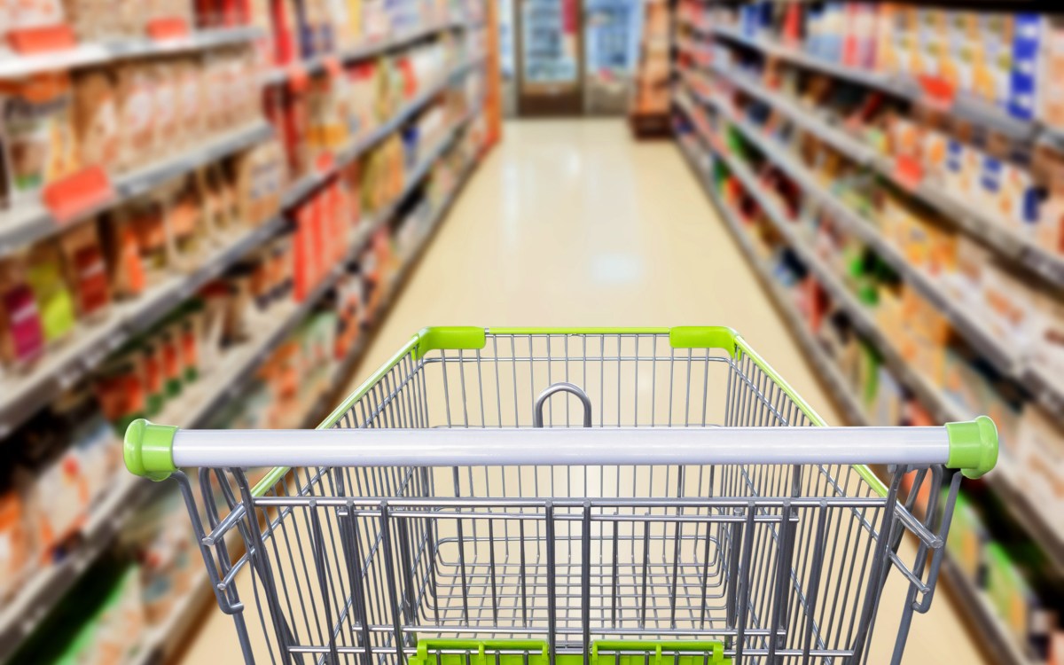 Supermarket aisle with empty shopping cart