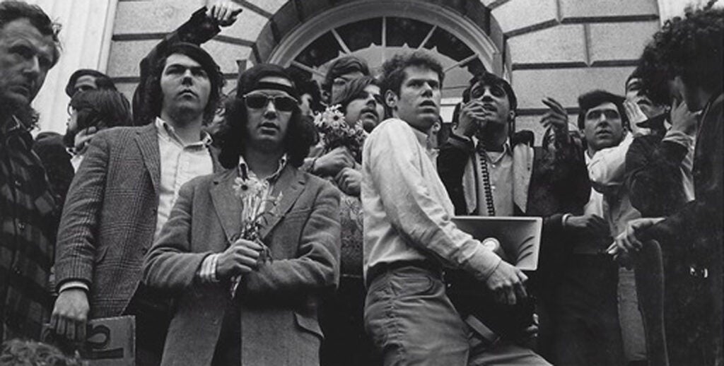 Nate Goldshlag in 1969 holding bullhorn amid protesters.