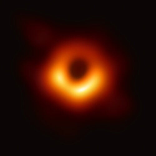 In the first picture of a black hole, it is outlined by emission from hot gas swirling around it under the influence of strong gravity near its event horizon.