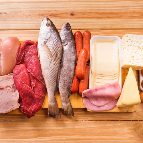 meats, fish, dairy, eggs, white meat on a wooden table as background