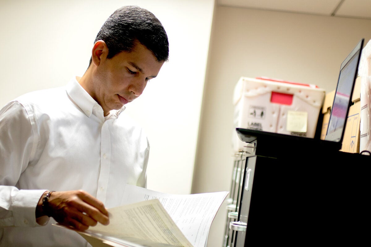 Salvador Peña looks at a file in an office
