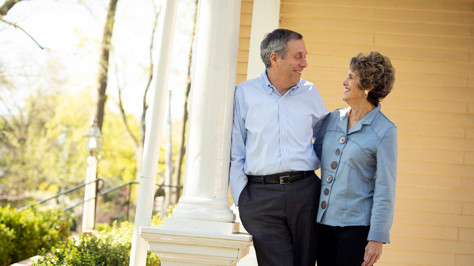 Larry and Adele Bacow standing on their porch of their Elmwood home.