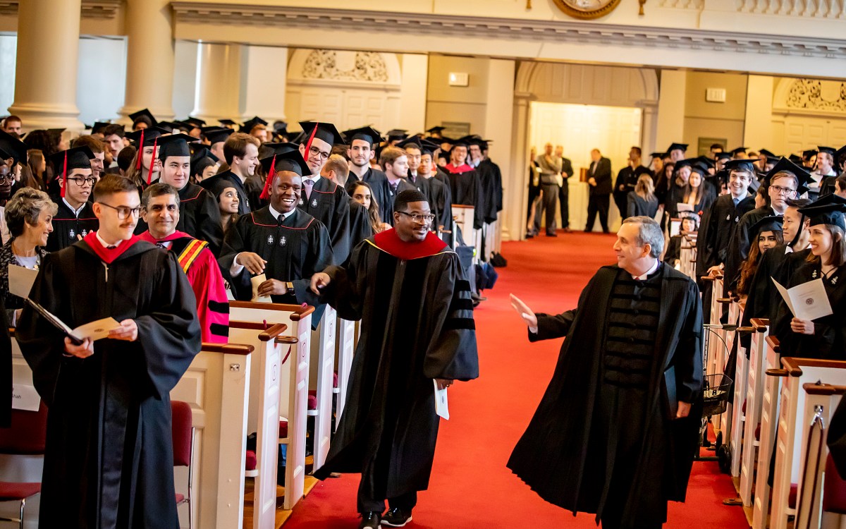 Larry Bacow and Jonathan Walton walk down the aisle of Memorial Church for the 2019 Baccalaureate Service.