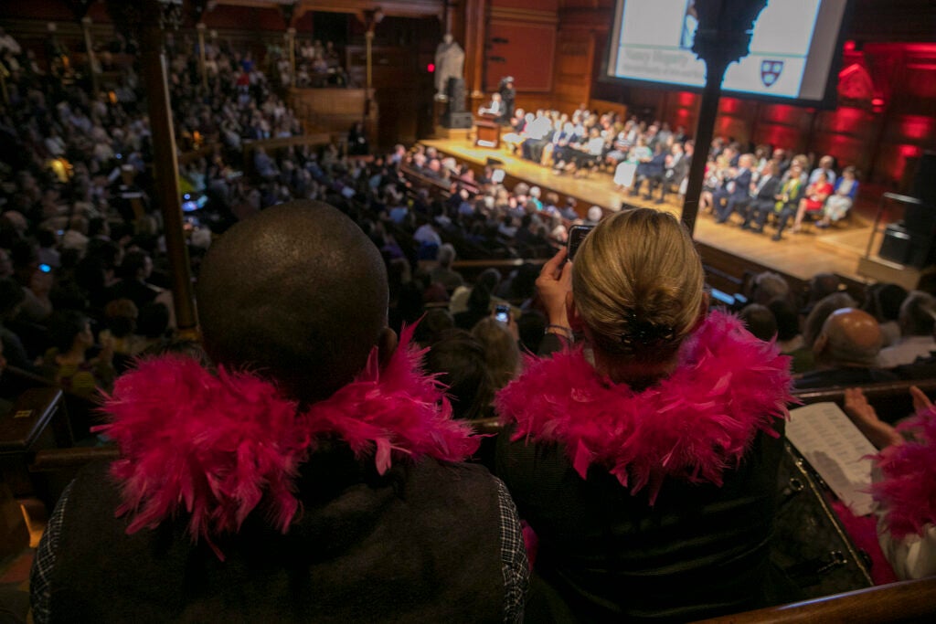 Two spectators wearing pink feather boas
