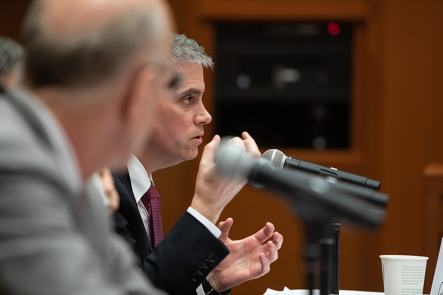 Man speaking into a microphone on a panel