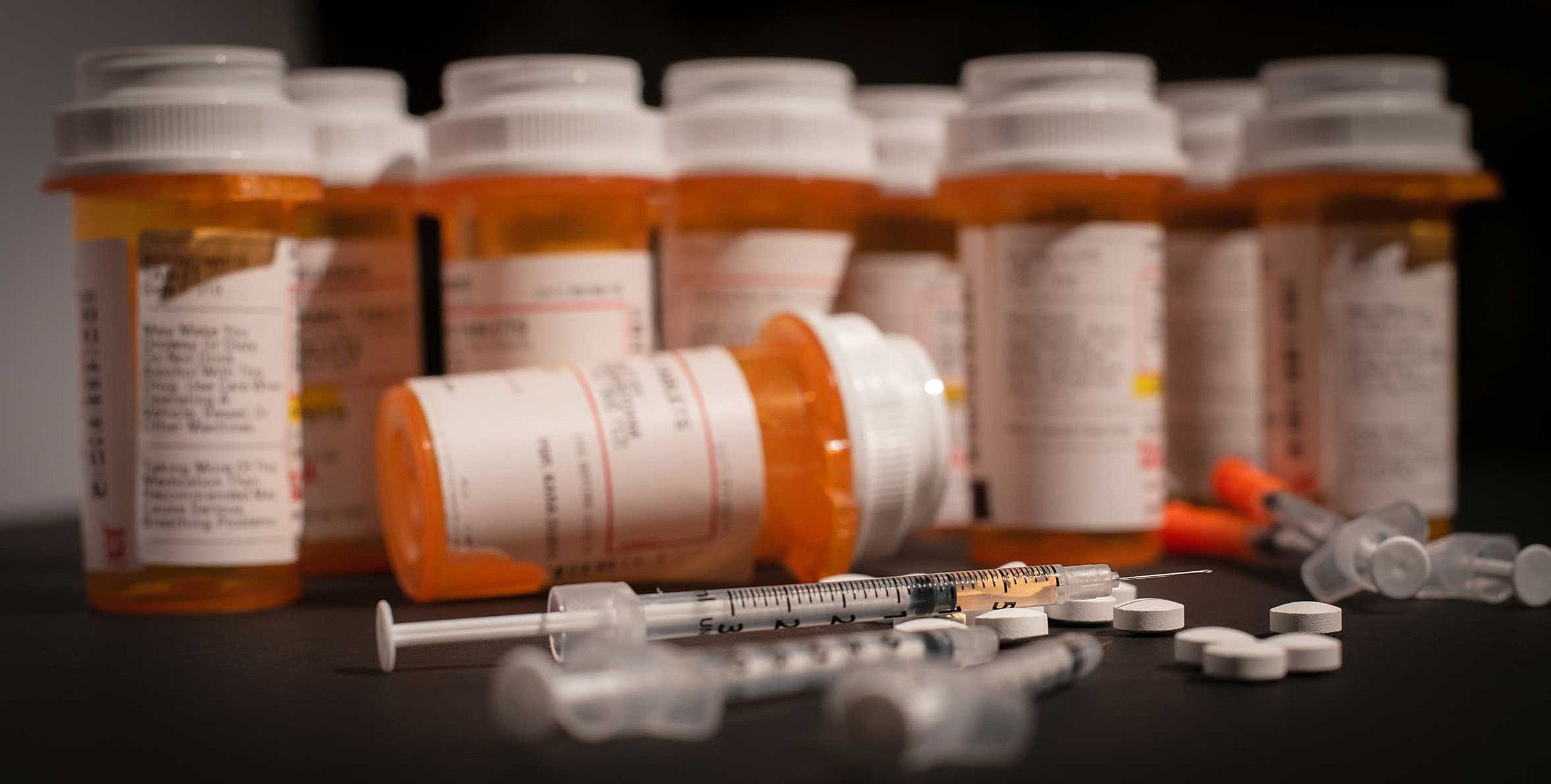 opioid bottles and a syringe