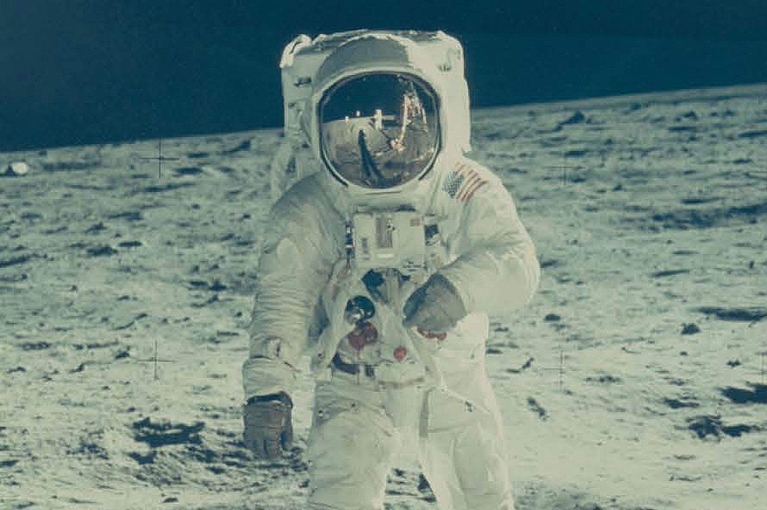 Buzz Aldrin on the moon with Neil Armstrong reflected in his visor.