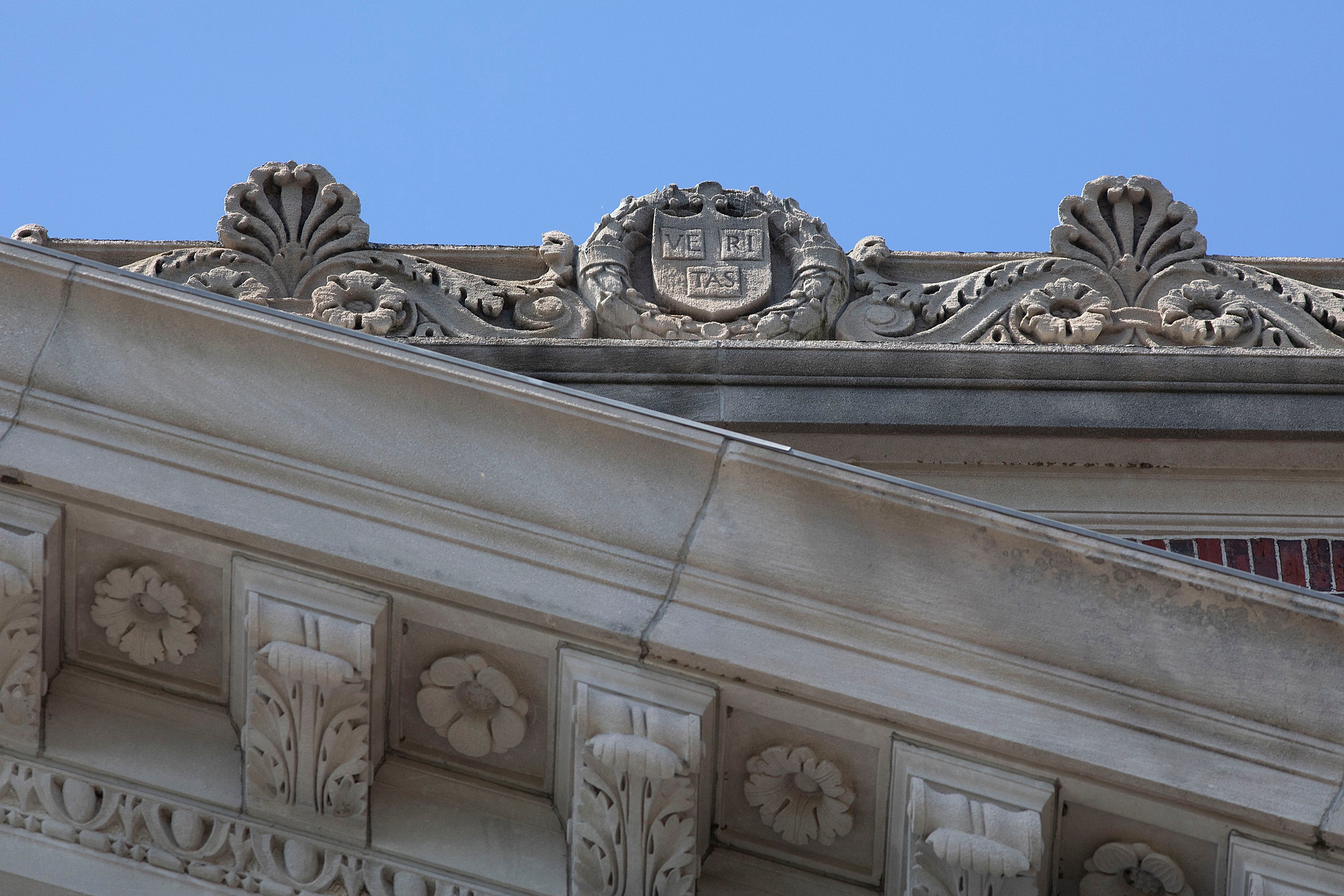 Views of Widener Library's roof, with stone veritas and Harvard shields.