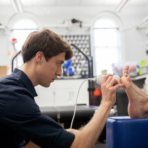 Nick Holowka, Postdoctoral Researcher, performs an ultra sound on callouses