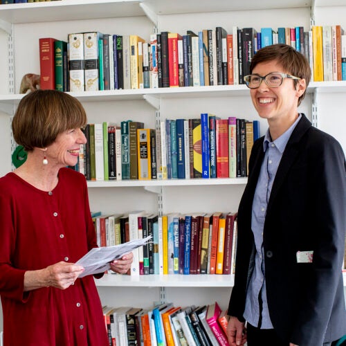 Kathleen Coleman (left) and Eleanor Finnegan chat in front of a bookcase