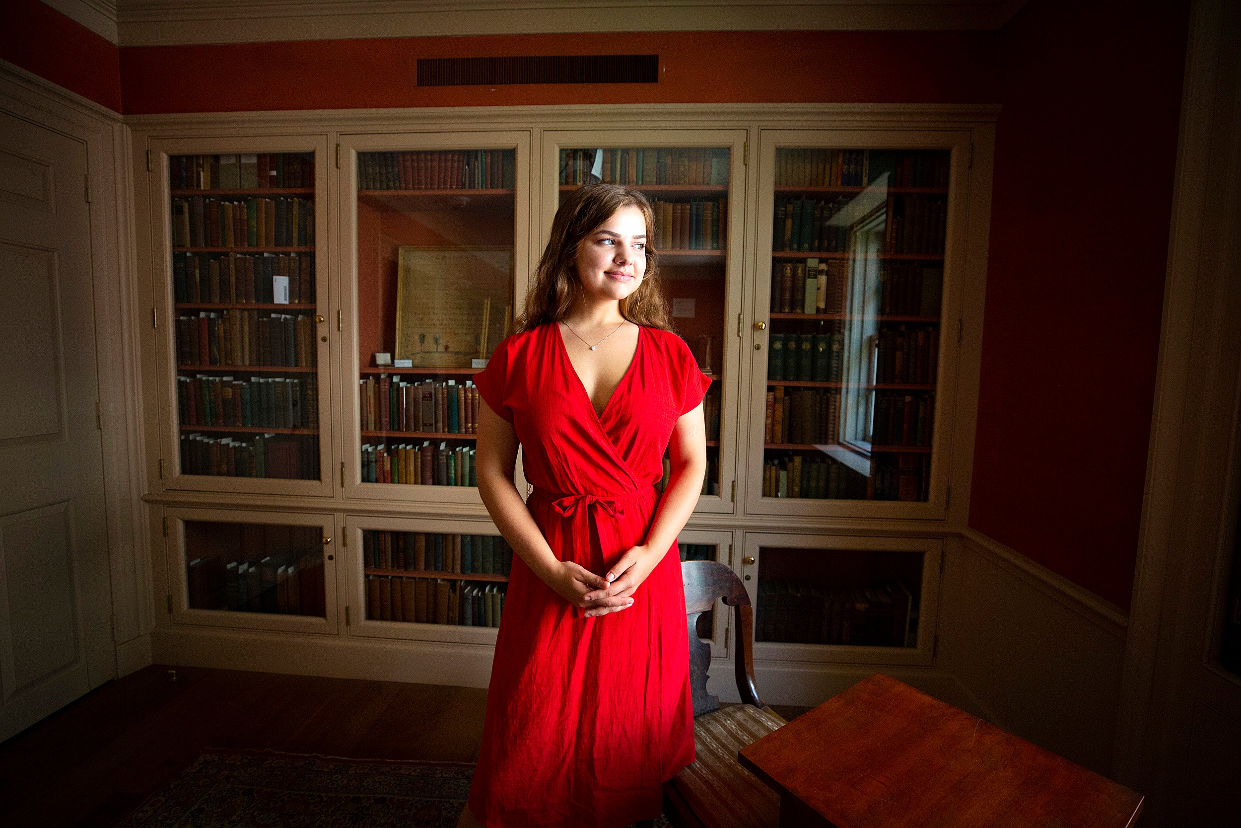 student in a red dress in the library