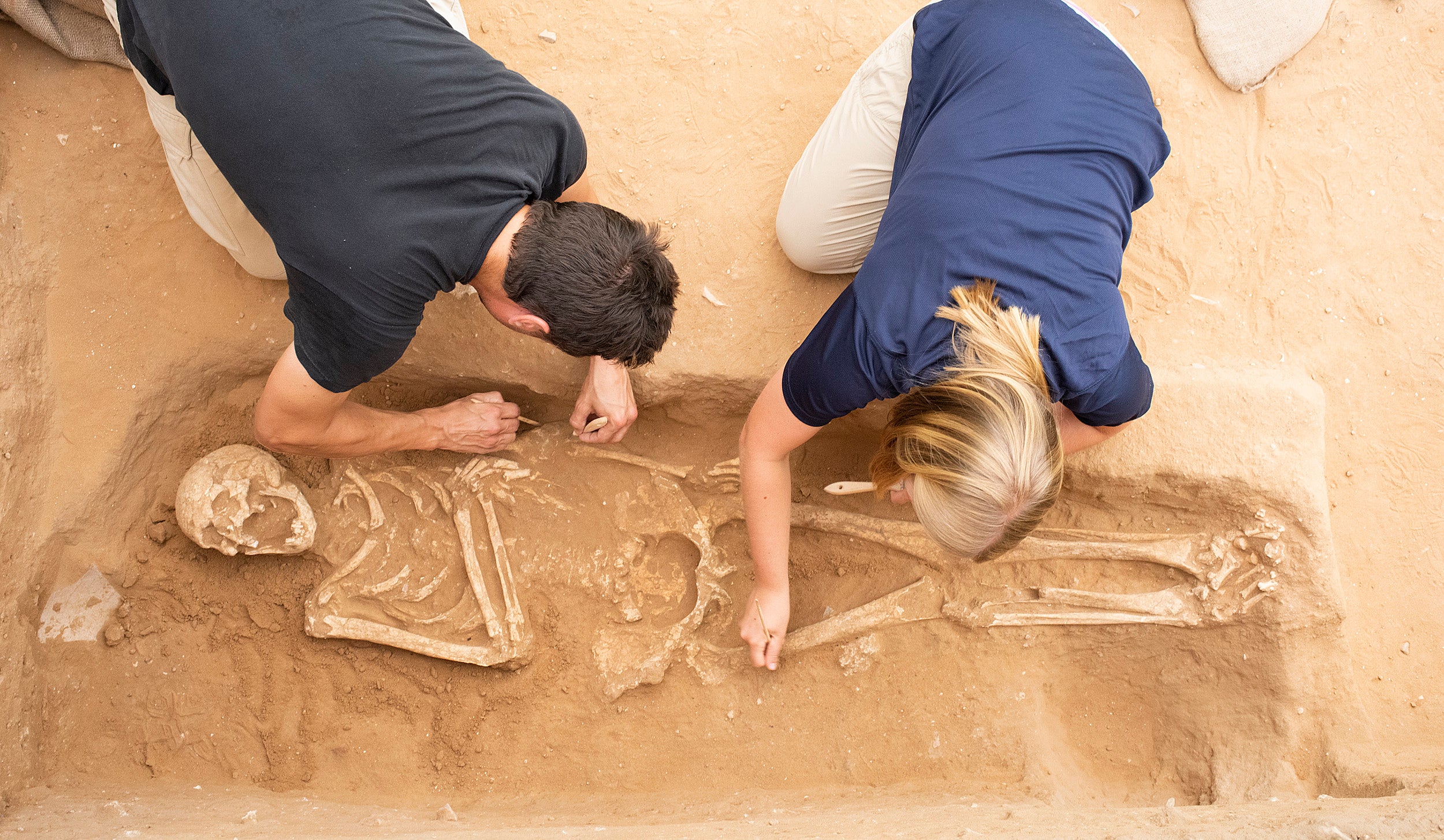 Archeologists excavating a skeleton