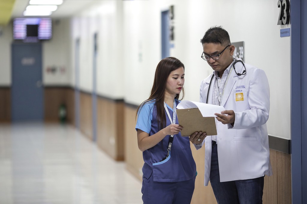 Doctor and assistant looking at a clipboard