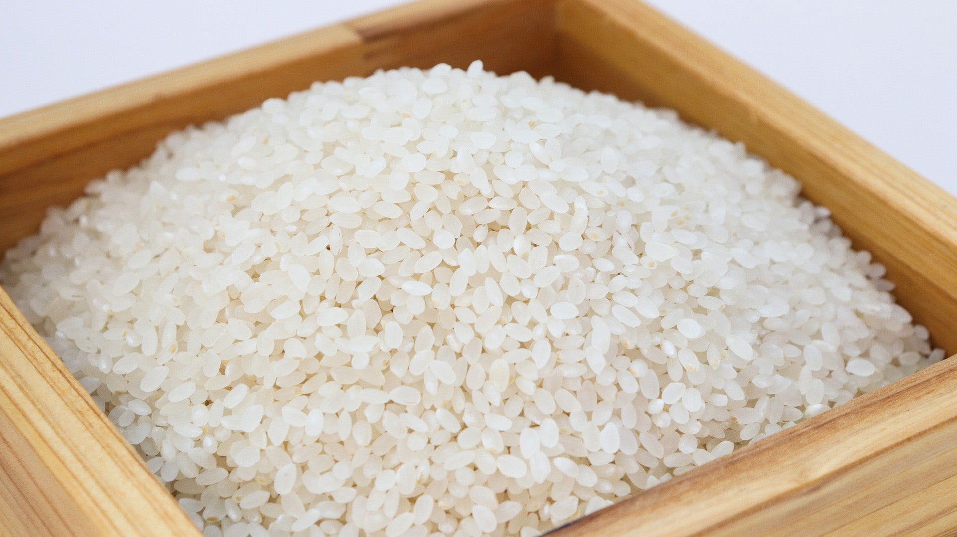 Uncooked rice in a wooden container